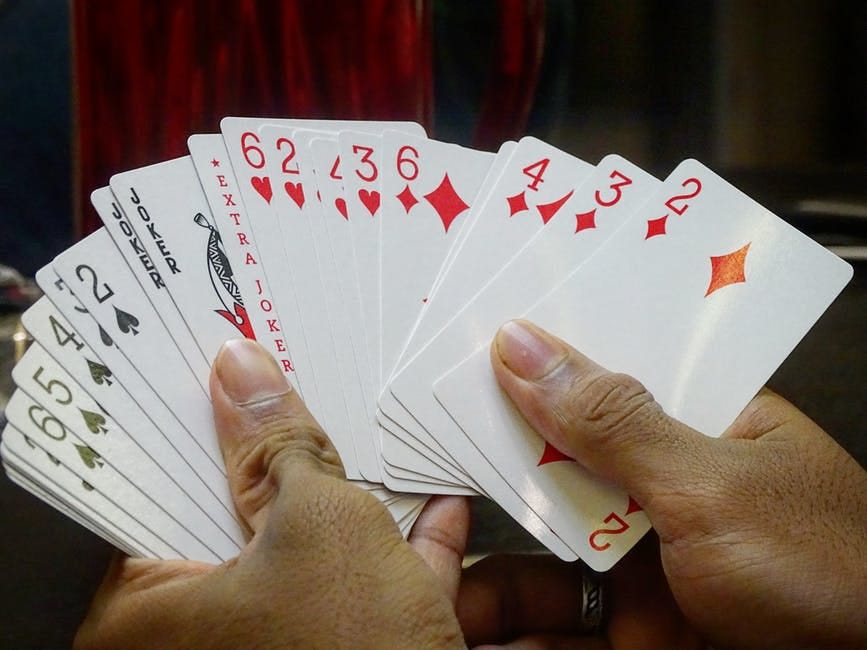 Two hands are holding a set of cards spread out like a fan